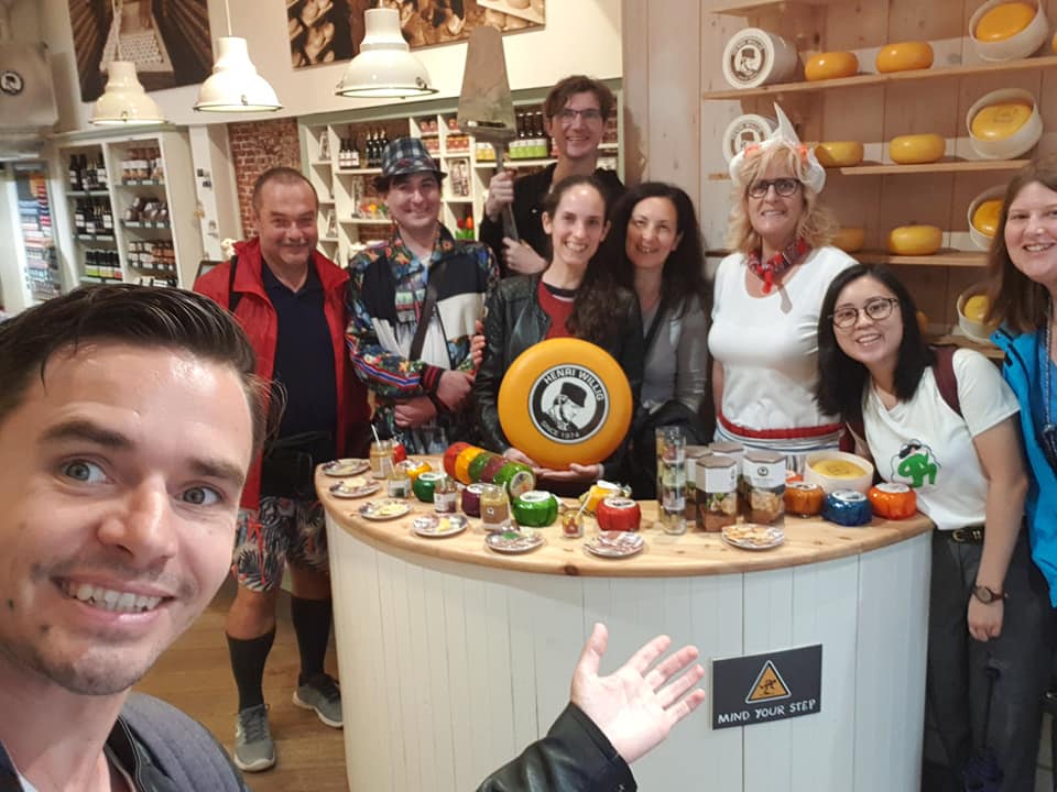 Guests and guide sharing Dutch food at a cheese shop in Amsterdam